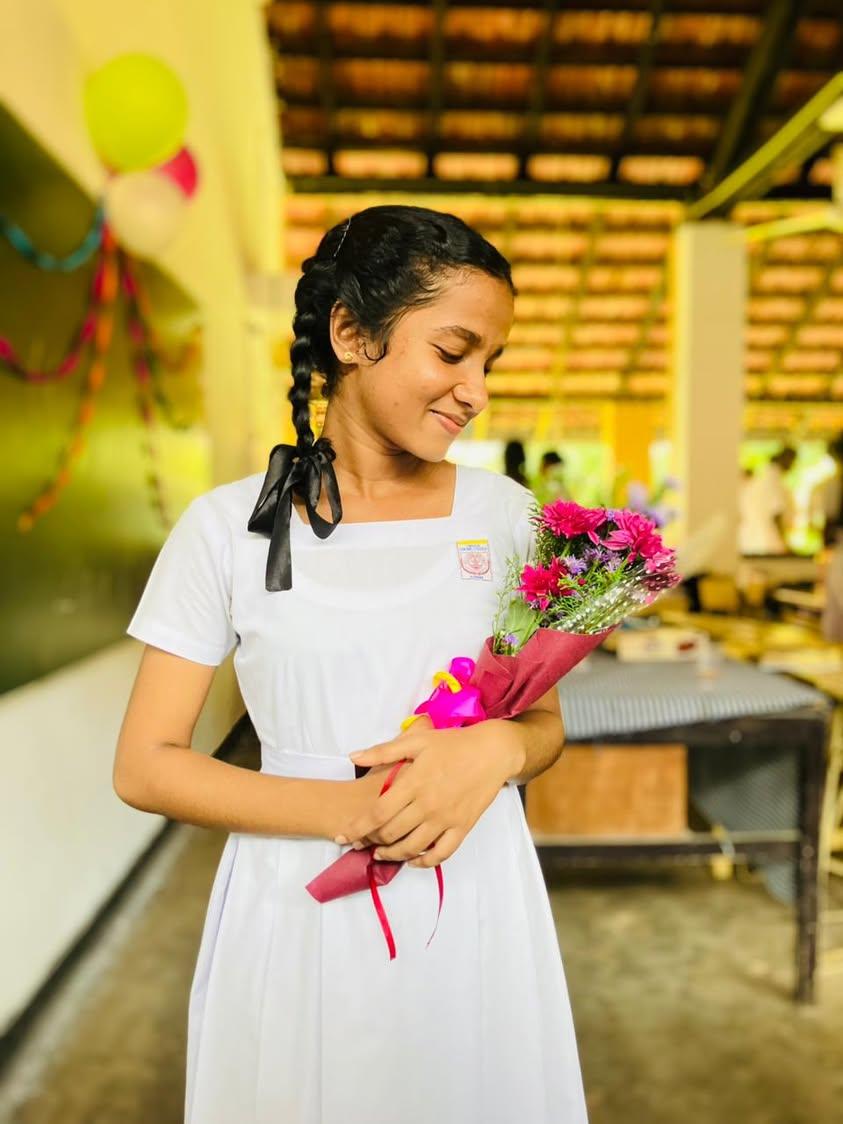 Chuutimanikaa in her school uniform holding flowers